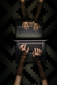 Mother and Daughter working at night with laptops photographed from above.