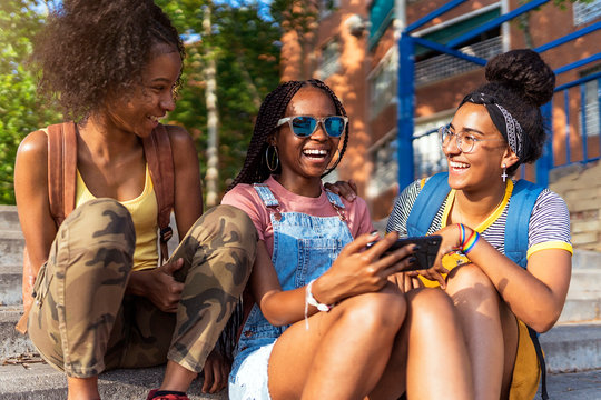 three African teenage girls using a smartphones