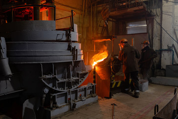 Factory employees working with liquid metal