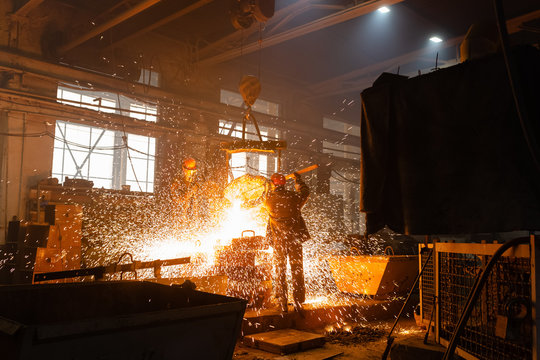 Unrecognizable workers in sparks of liquid metal