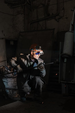 Man in protective glasses working on factory