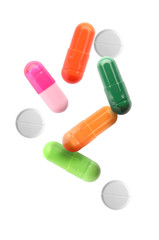 Different falling pills on white background