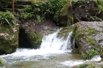 Beautiful landscape of cascade falls over mossy rocks, stones cover with moss, in a Mountain in Sichuan, China