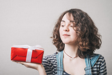 Woman hold gift. Isolated studio portrait. Smiling, happy girl.