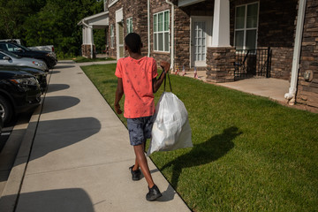 Pre Teen taking out garbage