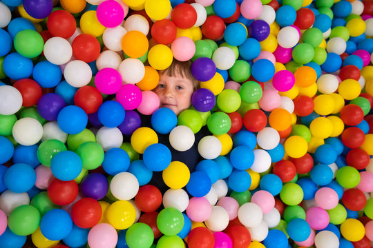 Cute smiling kids in sponge ball pool looking at camera