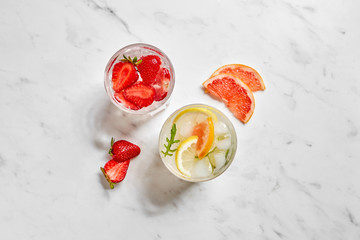 Sliced fruit with infused water in glasses