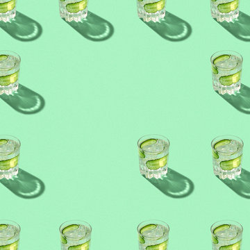 Pattern of full glasses with water and sliced cucumber