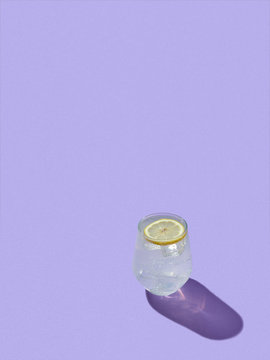 Refreshing lemon drink on lavender color background