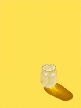 Refreshing lemon drink on yellow background