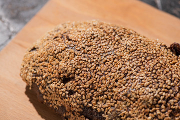 fresh baked black bread with sesame on cutting board