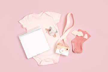 Pale pink cute baby bodysuit with mock up card. Set of kids clothes and accessories. Fashion...