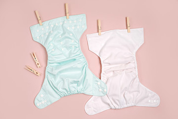 Reusable cloth baby diapers drying on a clothes  line. Eco friendly cloth nappies on a pink...