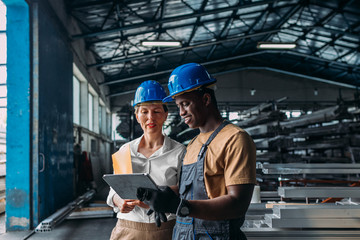 Worker talking with businesswoman in factory