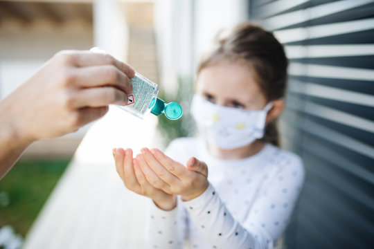 Small girl with face mask outdoors at home. Corona virus and quarantine concept.
