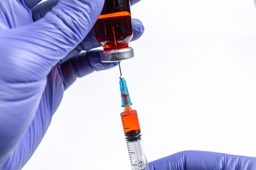 Drawing medicine from ampule into a syringe. Doctor in blue gloves. Medical mocku up.