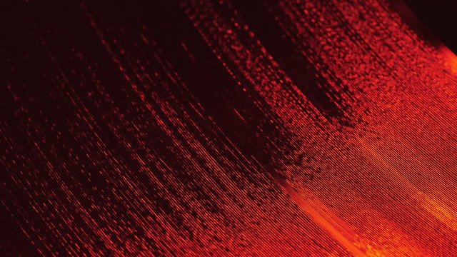 A fragment of a rotating vinyl record in the red rays of a disco. Audio equipment for dj. The moment of a spinning vinyl plate. Turntable vinyl record player