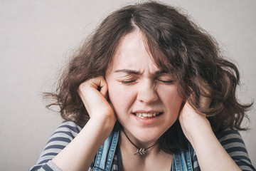 Young woman with  its hands covering his ears not to hear noise.