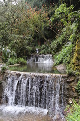 Obraz premium Beautiful landscape of cascade falls over mossy rocks, stones cover with moss, in a Mountain in Sichuan, China