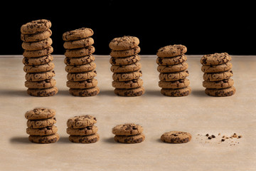 Steps of chocolate chip cookies being devoured. Isolated on beige background.