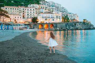 Adorable little girl on sunset in Amalfi town in Italy