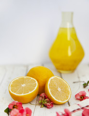 Obraz na płótnie Canvas Lemon juice in a glass jug, lemons on an empty white background.