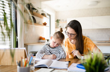 Mother and daughter learning indoors at home, Corona virus and quarantine concept.