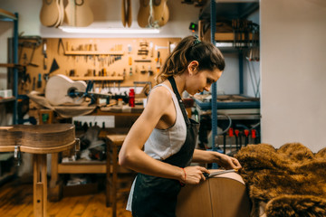 Young Woman Luthier working in handcrafted spanish guitar
