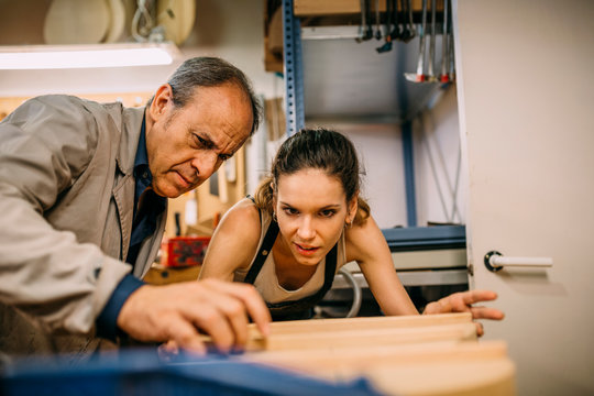 Luthiers working in traditional guitar making business - Powered by Adobe