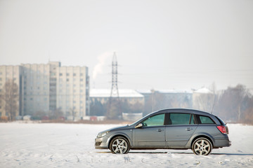 Car parked in snowy field on winter day.