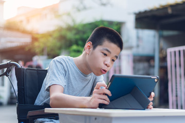 Disabled child on wheelchair happy time to use a tablet in the house, Study and Work at home for safety from covid 19, Life in the education age of special need kid, Happy disability boy concept.