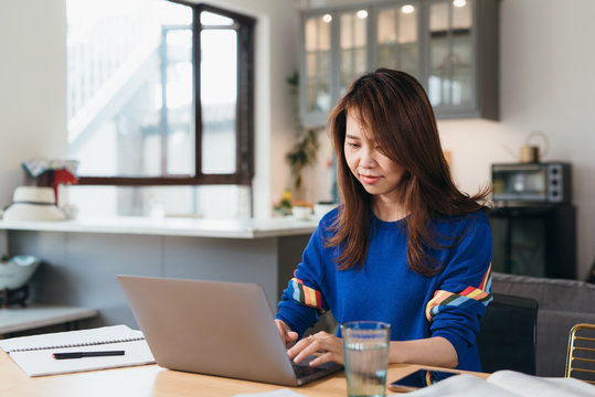 Young Asian woman working with computer at home