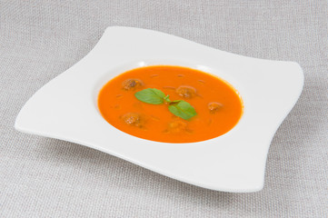 Mashed potato tomato soup with meatballs in an original plate on a gray background