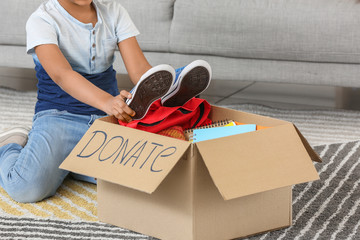 Little African-American boy with donations at orphan home