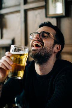Man laughs just as he was about to sip his beer