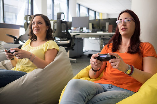 Female colleague playing video games in it office and having fun