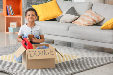 Little African-American boy with donations at orphan home