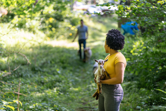 Young Woman Holding Baby Goat