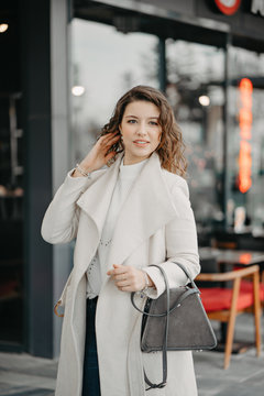 Beautiful young brunette girl walking on the restaurants street of the city