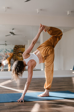 Anonymous pregnant doing dancer pose at yoga class
