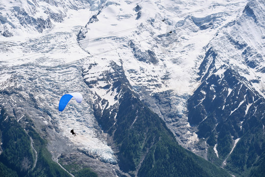 Paragliders fly above Chamonix from Brevent, France.