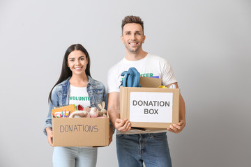 Volunteers with donations for orphans on grey background