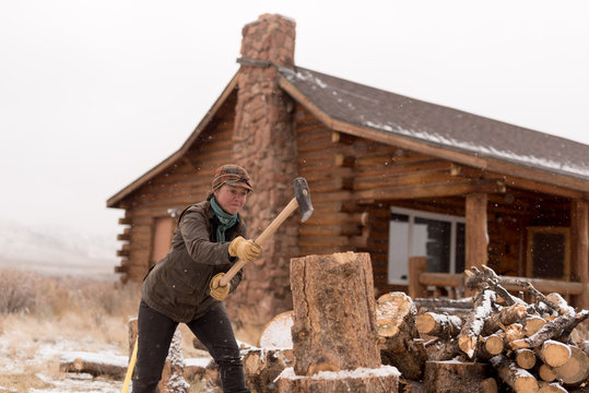 Ranch Manager and Cowgirl  cutting wood with a chainsaw