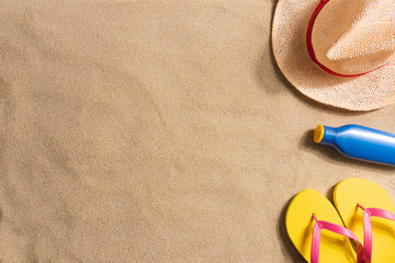 Fototapeta na wymiar Summer vacation composition. Sun cream, flip flops and straw hat on sand