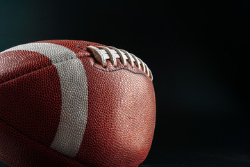 American foottball ball on dark background close up. American football concept