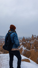 Man watching unique volcanic landscape at Red Valley in Cappadocia, Turkey. Epic valley landscape photography with a man between geologic rock formations in Cappadocia, Turkey