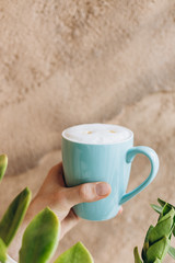 big blue coffee mug with milk on wall background. Copy space