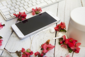White wireless keyboard, phone, headphones, tablet. Place a freelancer, businessman. White table