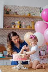 family on the table with a birthday cake and balloons