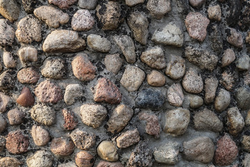 Masonry of multi colored small stones with a crack